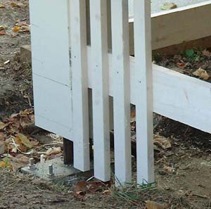 Close up showing how wooden upright is bolted to concrete footing